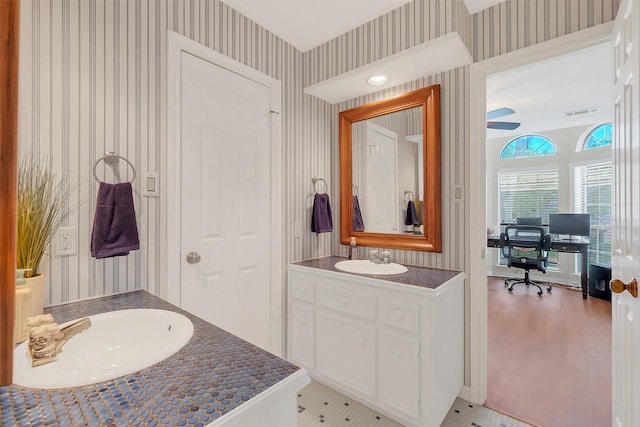 bathroom featuring wallpapered walls, vanity, and baseboards