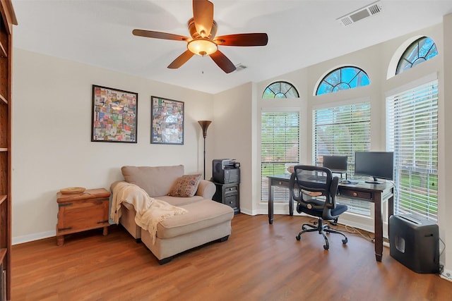 office area with a ceiling fan, wood finished floors, and baseboards