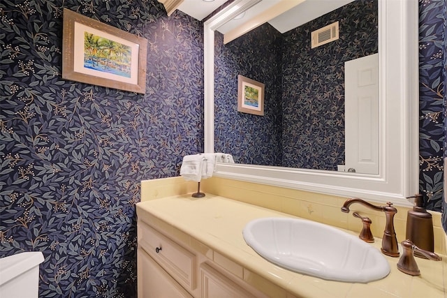 bathroom featuring wallpapered walls, vanity, and toilet