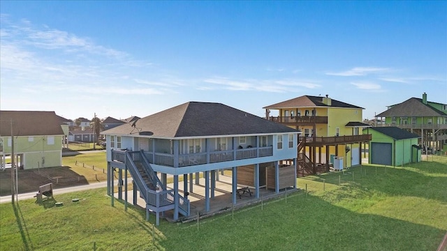 back of property with stairway, a deck, an outbuilding, and a lawn