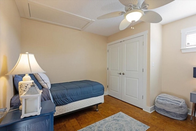 bedroom featuring attic access, wood finished floors, ceiling fan, a closet, and baseboards