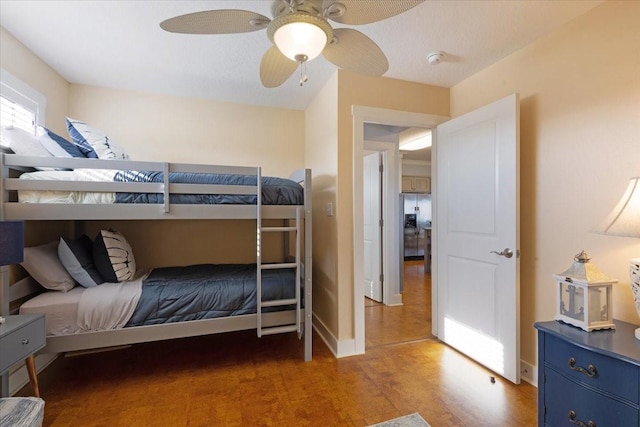 bedroom with light wood-type flooring, a ceiling fan, and baseboards