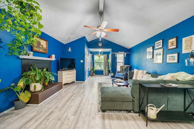 living area featuring wood finished floors, a ceiling fan, vaulted ceiling, and baseboards