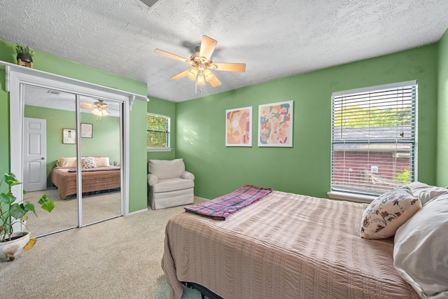 carpeted bedroom featuring ceiling fan, a textured ceiling, and a closet