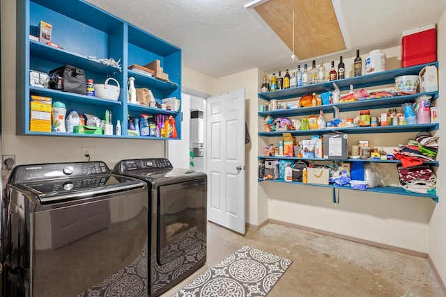 washroom with washer and clothes dryer, baseboards, attic access, and a textured ceiling
