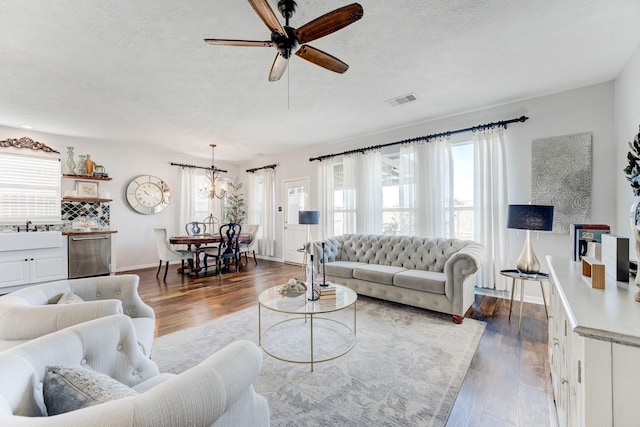 81 San Simeon Dr, Manvel, TX 77578 - living room with a ceiling fan, dark wood-style floors, a textured ceiling, baseboards, and a chandelier