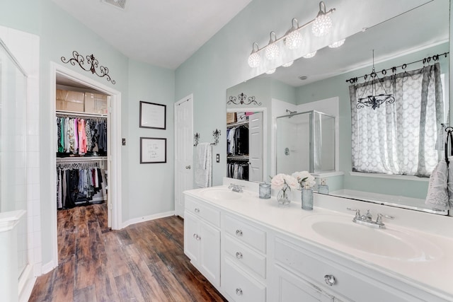 81 San Simeon Dr, Manvel, TX 77578 - bathroom with a shower stall, wood finished floors, a spacious closet, baseboards, and double vanity