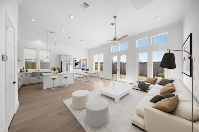 living room with light wood finished floors, a ceiling fan, french doors, and recessed lighting