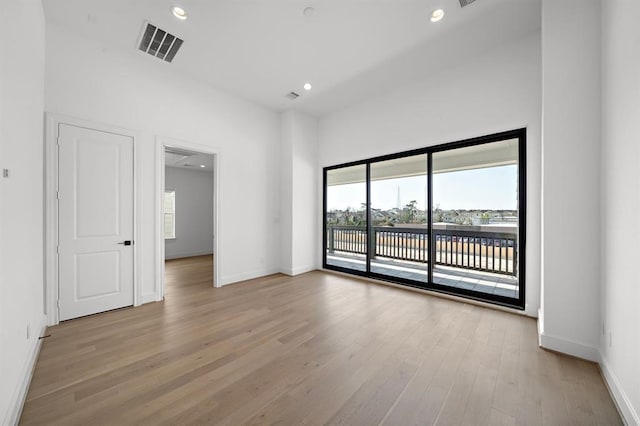 spare room with plenty of natural light, light wood finished floors, baseboards, and recessed lighting