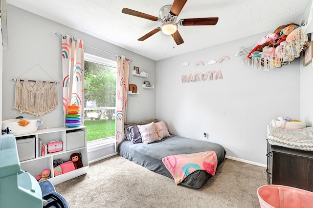 carpeted bedroom featuring multiple windows, baseboards, and a ceiling fan