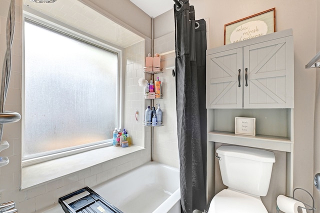 bathroom featuring toilet and shower / tub combo with curtain