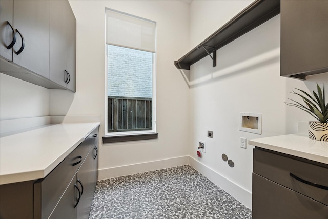 washroom featuring cabinet space, electric dryer hookup, washer hookup, and baseboards