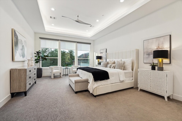 carpeted bedroom featuring recessed lighting, a tray ceiling, and baseboards