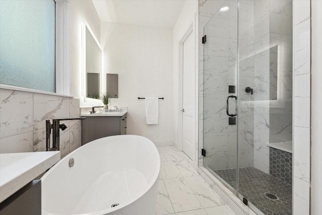 bathroom with vanity, a marble finish shower, marble finish flooring, and a freestanding bath