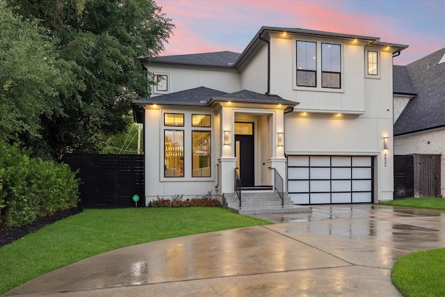 view of front of home with concrete driveway, an attached garage, stucco siding, and a shingled roof