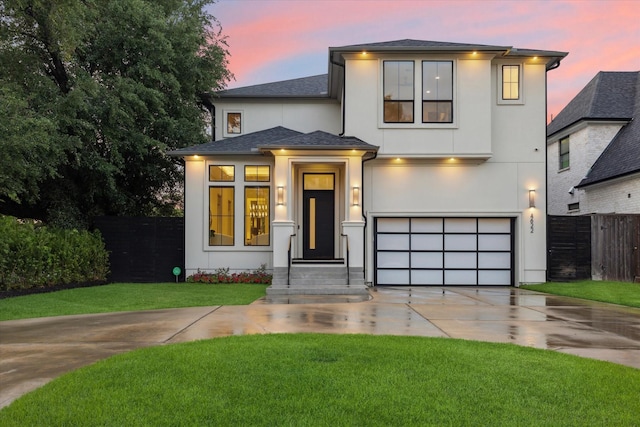 view of front of property with concrete driveway, an attached garage, stucco siding, and a shingled roof