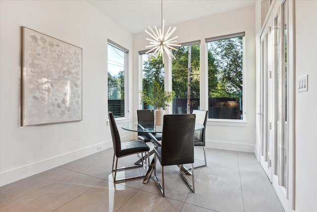 dining space featuring a chandelier, tile patterned floors, and baseboards