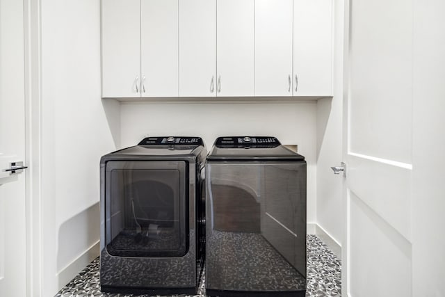 washroom with washer and dryer, cabinet space, and baseboards
