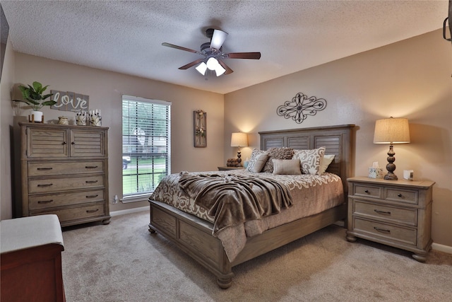bedroom with light carpet, baseboards, a textured ceiling, and a ceiling fan
