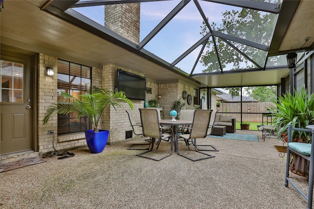 view of patio featuring outdoor dining space, a lanai, and fence