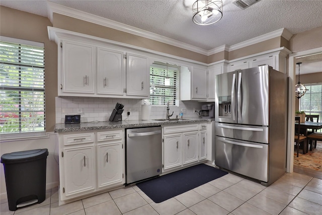 kitchen with stainless steel appliances, a sink, white cabinetry, backsplash, and a textured ceiling