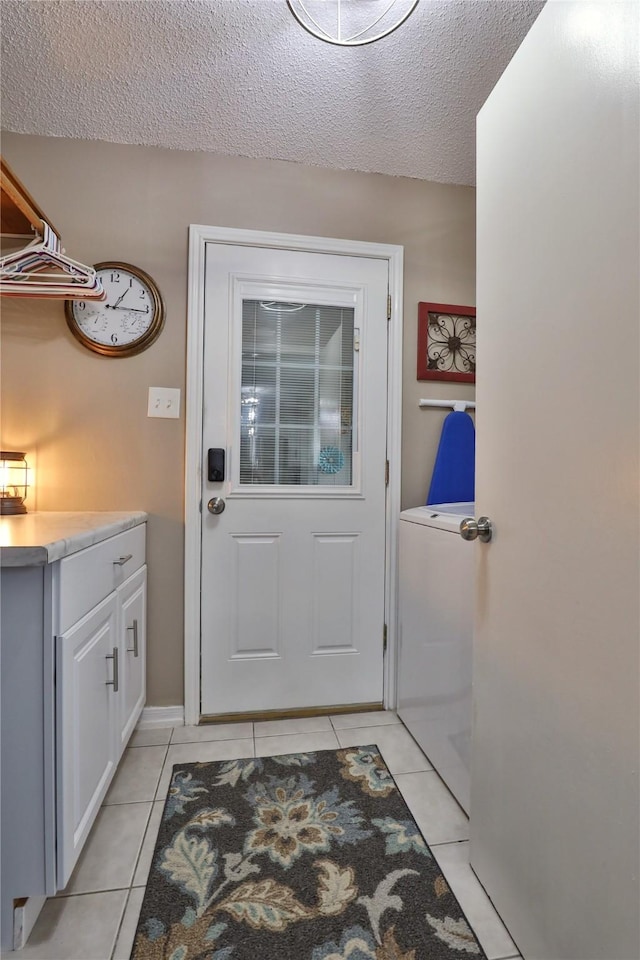 entryway with light tile patterned floors, a textured ceiling, and washer / clothes dryer