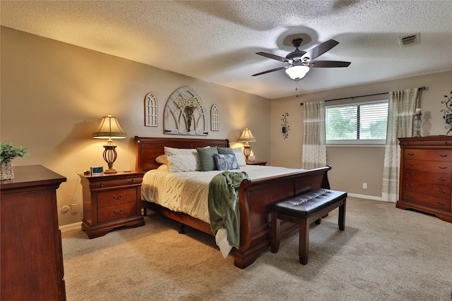 bedroom featuring light carpet, a textured ceiling, baseboards, and a ceiling fan