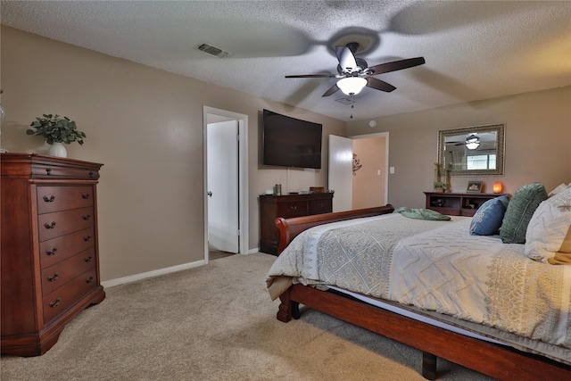 bedroom featuring light colored carpet, baseboards, ceiling fan, and a textured ceiling