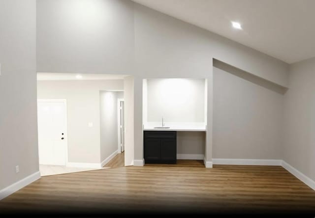 1703 Grand Valley Dr, Houston, TX 77090 - additional living space featuring light wood-type flooring, baseboards, bar with sink, and high vaulted ceiling