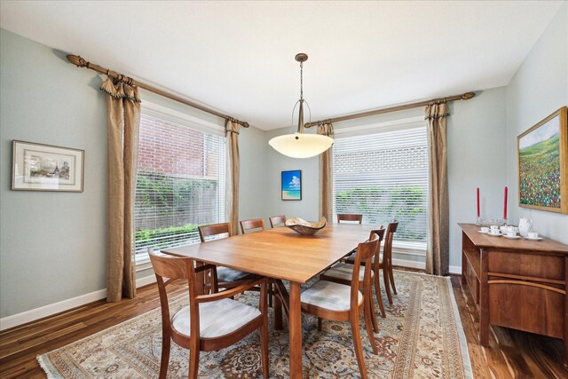 dining space with baseboards and wood finished floors