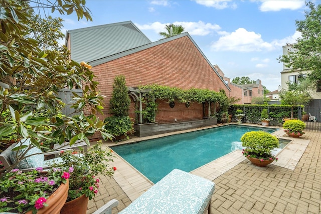 view of pool with a fenced backyard and a patio