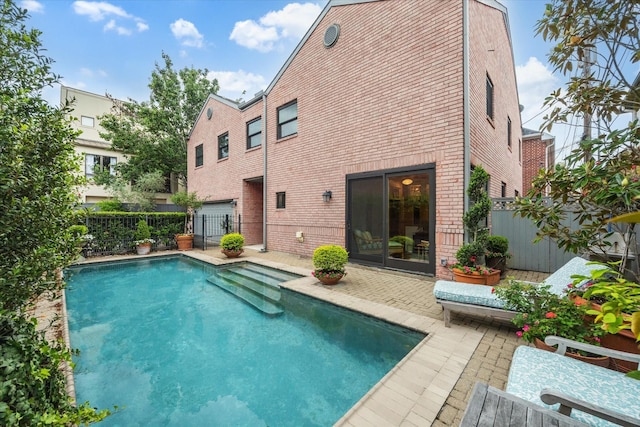 view of swimming pool featuring fence and a patio