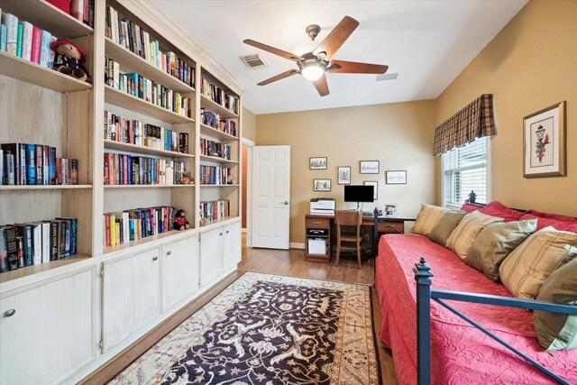 living area featuring a ceiling fan, wood finished floors, and a desk