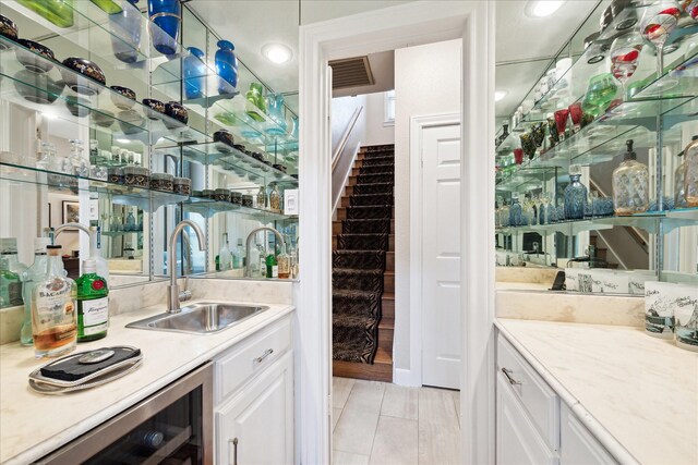 indoor wet bar featuring beverage cooler and stairway