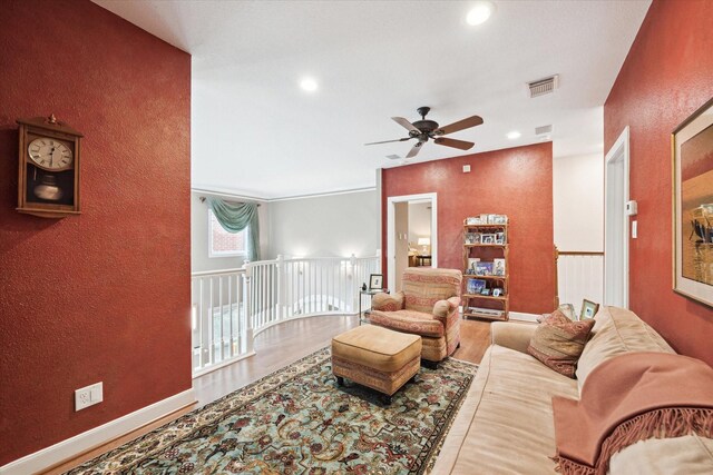 living area featuring a ceiling fan, wood finished floors, a textured wall, and recessed lighting
