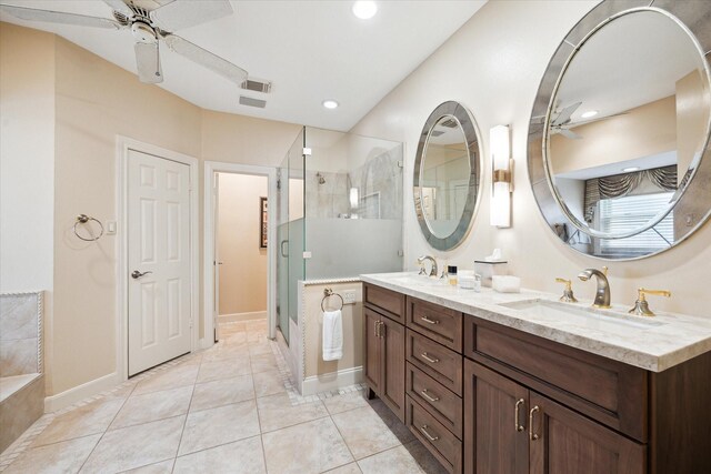 bathroom featuring ceiling fan, a tile shower, double vanity, tile patterned flooring, and recessed lighting