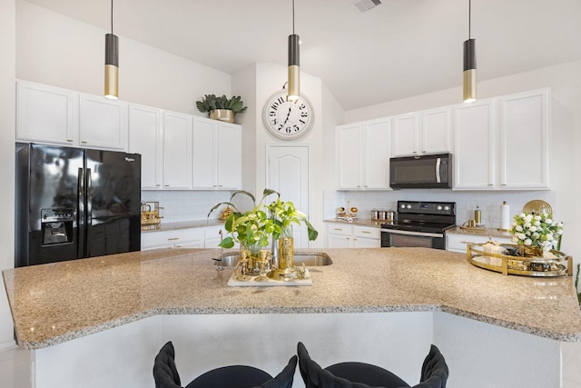 7923 Cheyenne Hills Trl, Richmond, TX 77406 - kitchen featuring black appliances, tasteful backsplash, a breakfast bar, white cabinetry, and vaulted ceiling