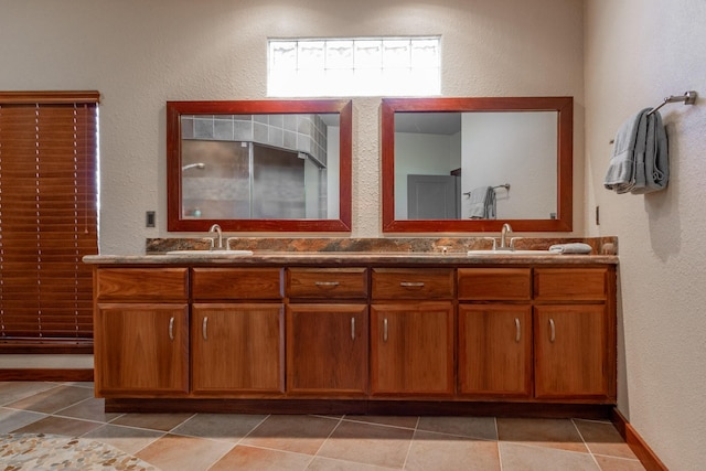 full bathroom with a textured wall, double vanity, and tile patterned flooring