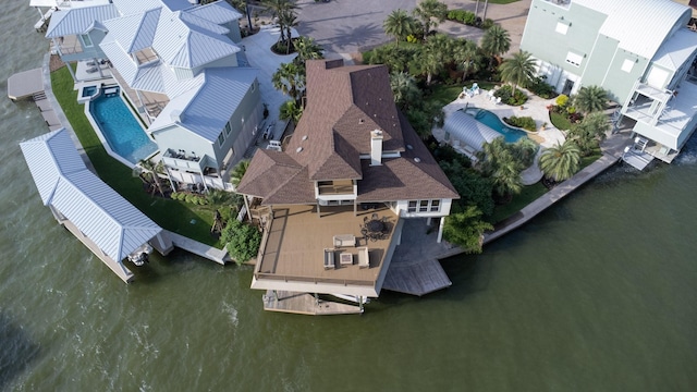 drone / aerial view of a pool area and a nearby body of water
