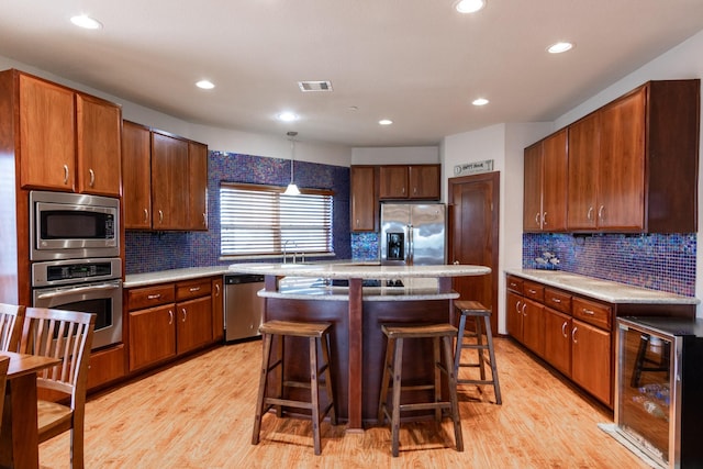 kitchen featuring stainless steel appliances, beverage cooler, tasteful backsplash, light wood-style floors, and recessed lighting