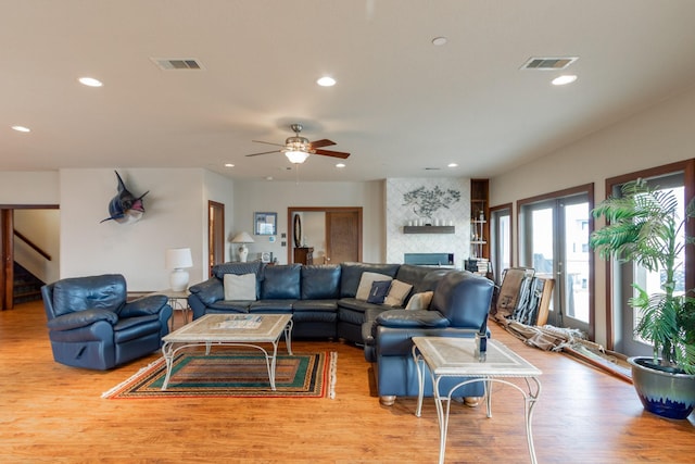 living room with wood finished floors, a ceiling fan, recessed lighting, stairs, and a fireplace