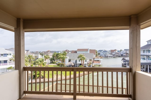 balcony with a residential view and a water view