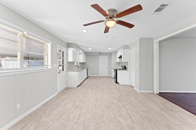 unfurnished living room with a ceiling fan, a sink, a textured ceiling, and recessed lighting