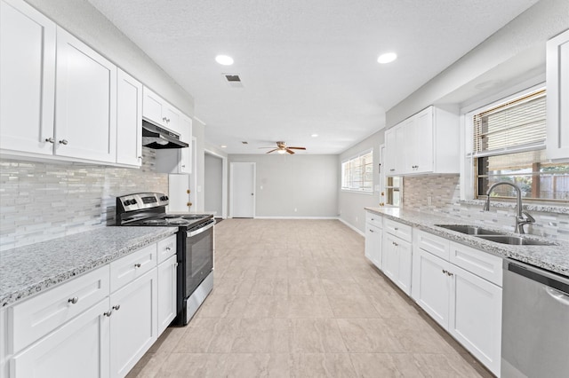kitchen featuring stainless steel appliances, a sink, under cabinet range hood, a ceiling fan, and backsplash