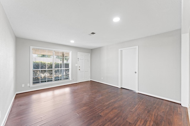 unfurnished room with dark wood-style flooring, baseboards, and recessed lighting