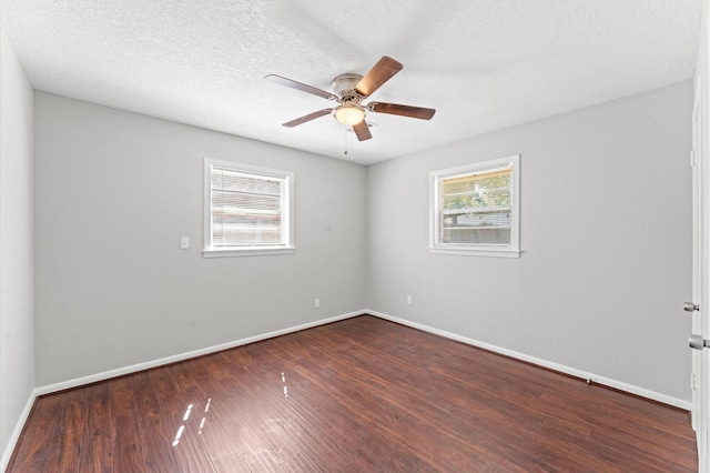spare room with dark wood-style flooring, baseboards, and a ceiling fan