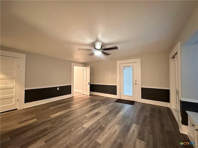 unfurnished living room featuring wood finished floors, a ceiling fan, and baseboards