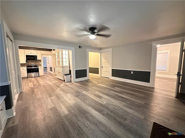 unfurnished living room featuring wood finished floors, ceiling fan, and baseboards