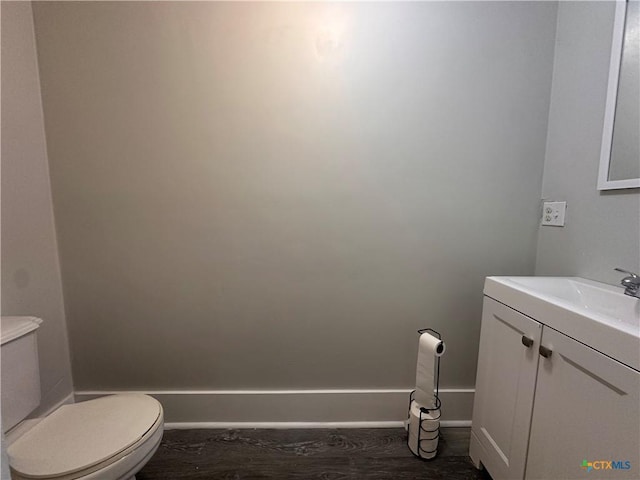 bathroom featuring toilet, vanity, and baseboards