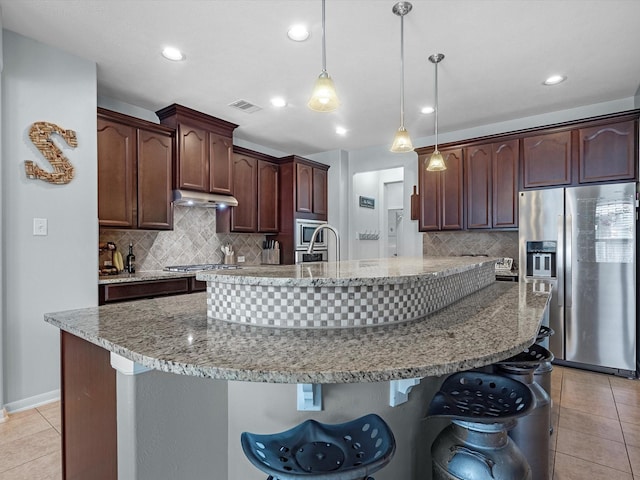 kitchen featuring stainless steel appliances, light tile patterned floors, decorative backsplash, under cabinet range hood, and recessed lighting